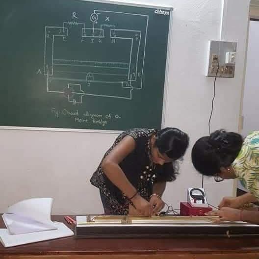BIORTON students setting up a metre-bridge experiment beside its circuit diagram